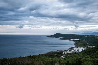 Scenic view of sea and townscape against sky