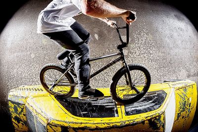 Low section of man with bicycle on road