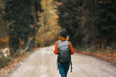 Rear view of woman walking on road