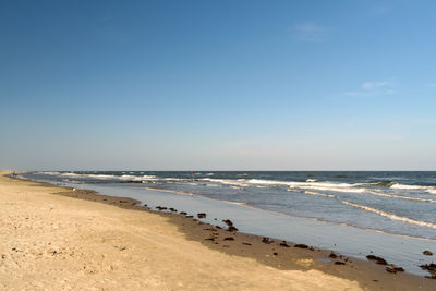 Scenic view of beach against clear blue sky