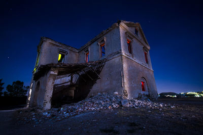 Low angle view of abandoned building against sky at night