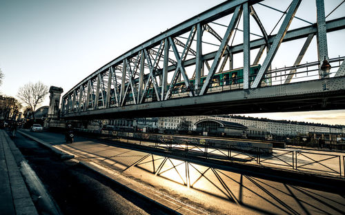 Train on bridge in city against sky