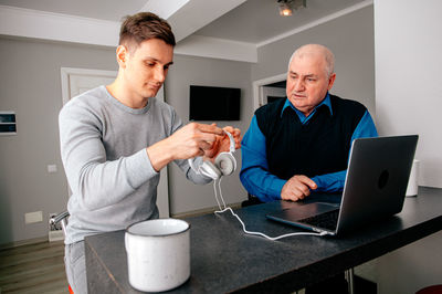 Grandfather with grandson adjusting headphones