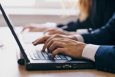 Midsection of woman using laptop on table