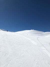 Scenic view of snowcapped mountains against clear blue sky