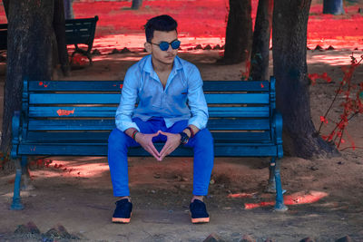 Full length of young man sitting on bench