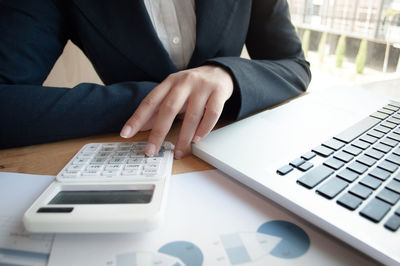 Midsection of man using laptop on table