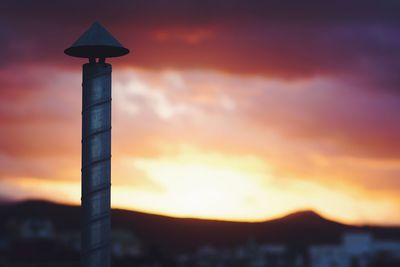 Silhouette tower against dramatic sky during sunset