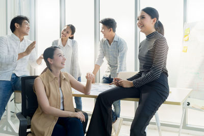 Cheerful colleagues talking in office