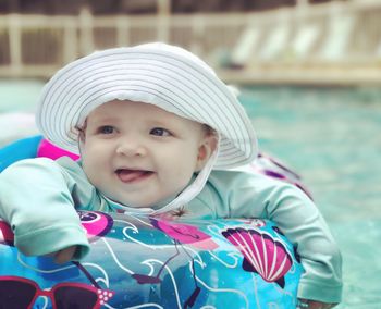 Close-up of cute baby girl in inflatable ring floating on swimming pool