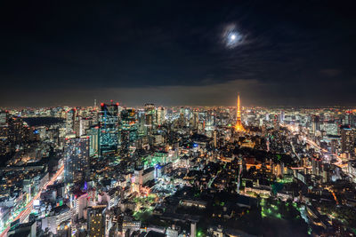 Tokyo tower amidst illuminated cityscape at night