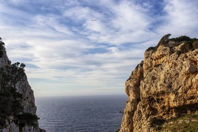 Rock formations by sea against sky