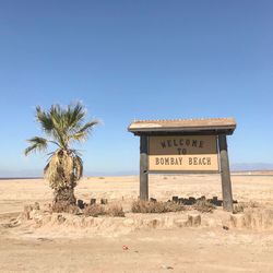 Information sign on desert against clear sky