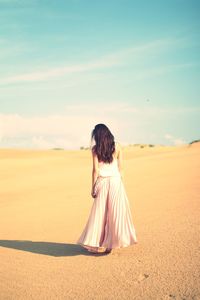 Rear view of woman standing on land against sky