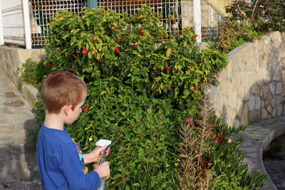 Side view of boy playing in yard