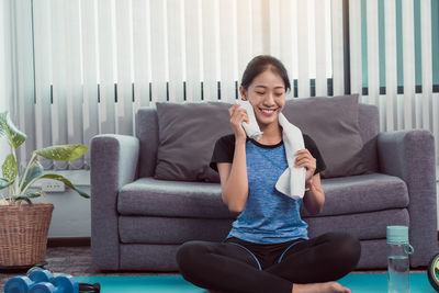 Full length of woman sitting on sofa