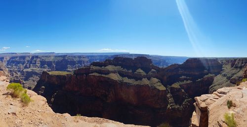 Panoramic view of rock formations against blue sky