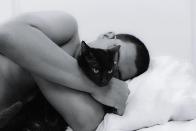 Portrait of man hugging cat