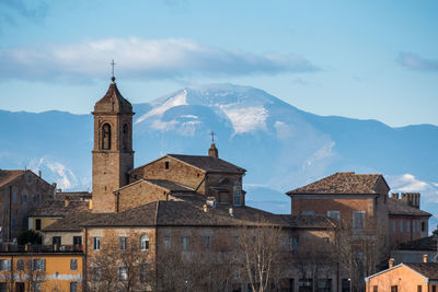 Buildings against sky with mountains in background