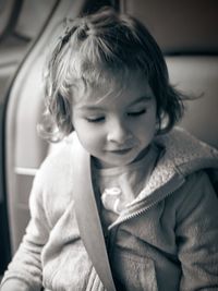 Close-up of girl looking down while sitting in car