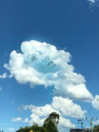 Low angle view of trees against blue sky