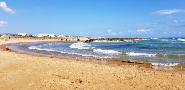 Scenic view of beach against blue sky