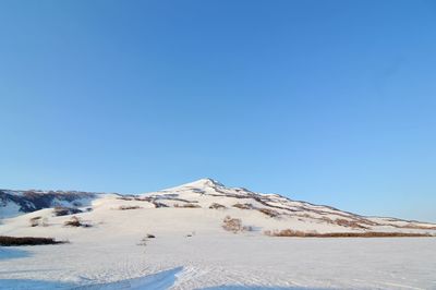 Scenic view of snowcapped mountains against clear blue sky