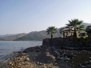 Scenic view of sea and buildings against clear sky