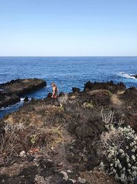 High angle view of woman walking on rocky shore