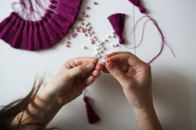 Woman working with threads and beads close-up, concept creativity, hobby and small business.