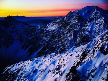 Scenic view of snowcapped mountains against sky during sunset