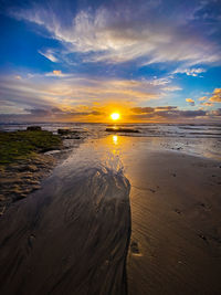 Water way on beach leading to ocean at beautiful sunset at swamis, encinitas, san diego, california