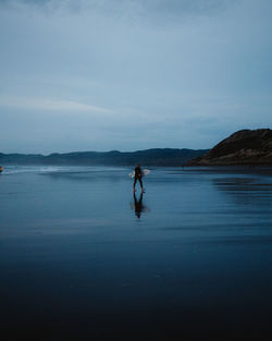 Man standing on beach against sky