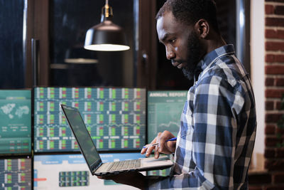 Side view of businessman using laptop at office