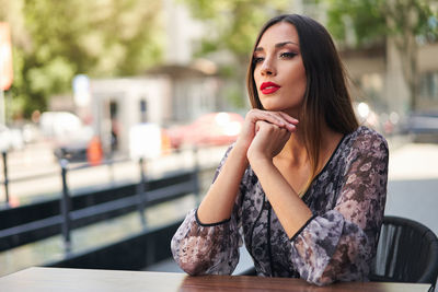 Portrait of young woman sitting outdoors