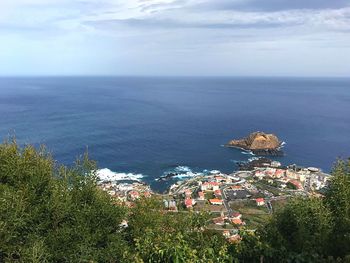 High angle view of townscape by sea against sky