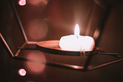 Close-up of illuminated tea light candles on table