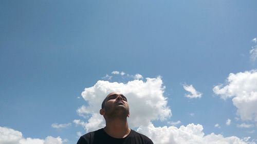 Low angle view of young man against sky