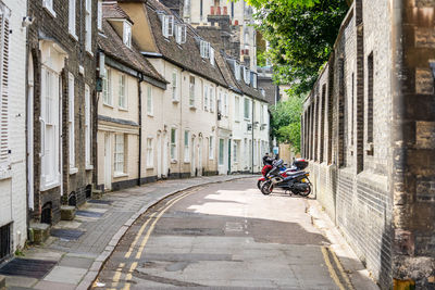 People riding motorcycle on street amidst buildings in city