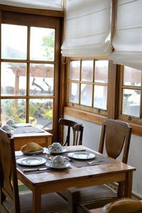 Empty table and chairs by window