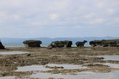 Rocks on beach against sky