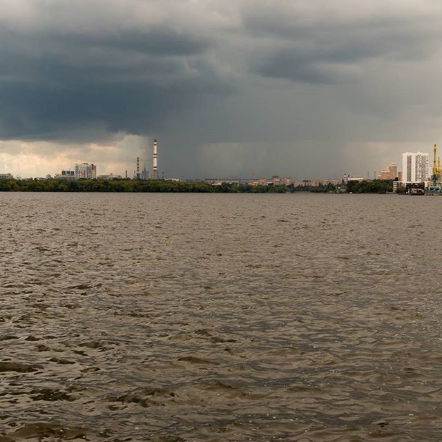 building exterior, water, architecture, sky, built structure, waterfront, cloud - sky, city, sea, cloudy, river, rippled, cloud, cityscape, nature, scenics, mid distance, tranquility, weather, urban skyline