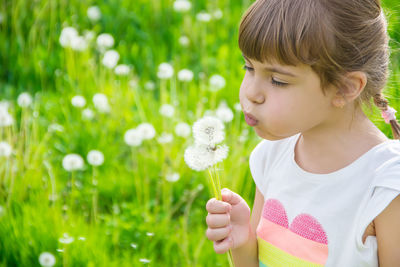 Portrait of girl blowing flowers