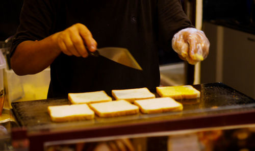 Midsection of man preparing food in kitchen