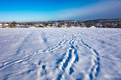 Scenic view of landscape against blue sky during winter