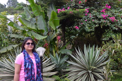 Portrait of woman wearing sunglasses while standing in park