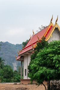 Temple by building against sky