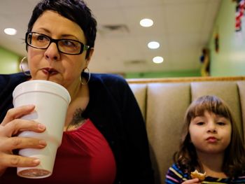 Close-up of woman and daughter having food in restaurant