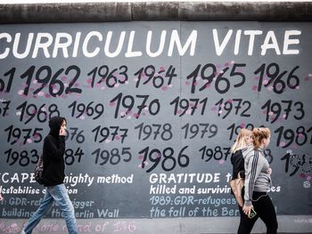 Woman with text on wall in city