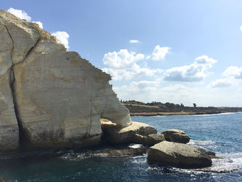 Rear view of woman by water against sky